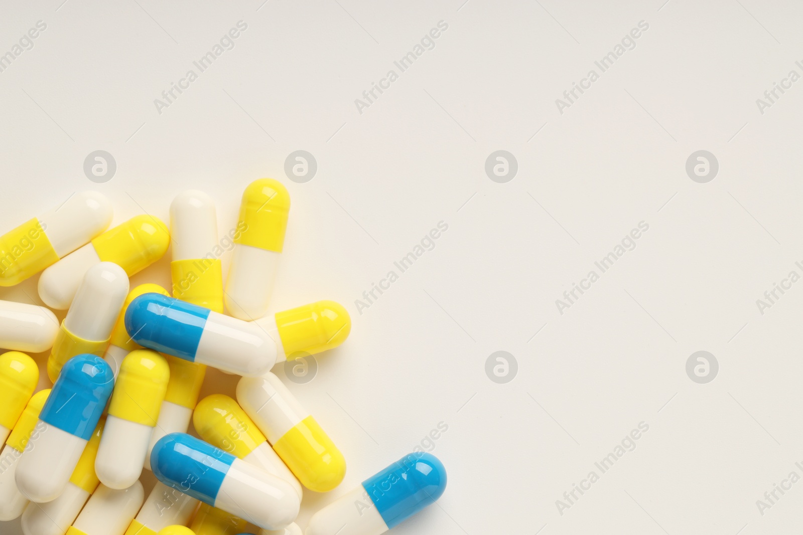 Photo of Antibiotic pills on white background, top view. Space for text