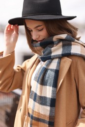 Beautiful woman in warm scarf and hat outdoors