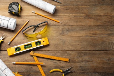 Photo of Flat lay composition with building level and other construction tools on wooden table, space for text