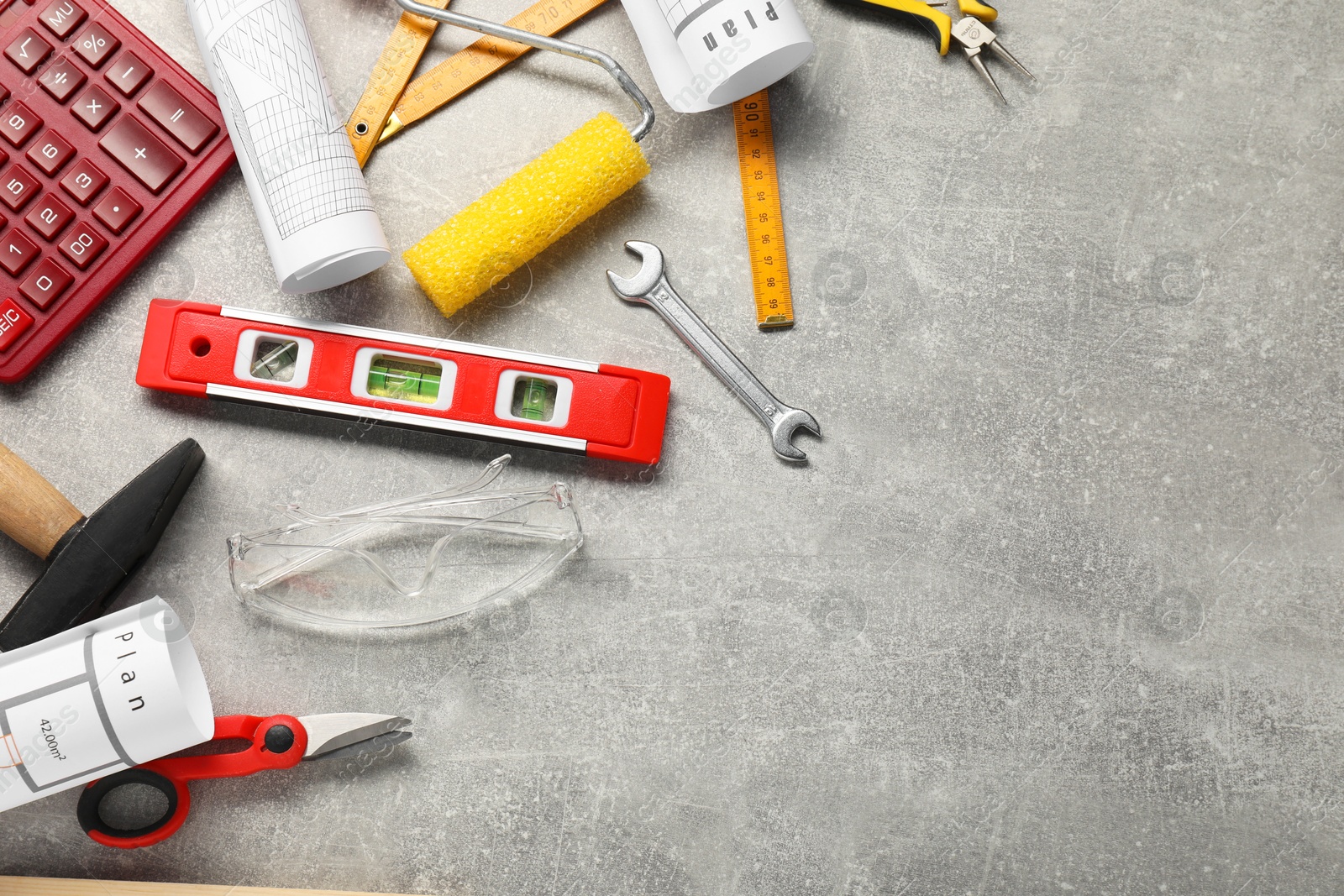 Photo of Flat lay composition with building level and other construction tools on grey table, space for text