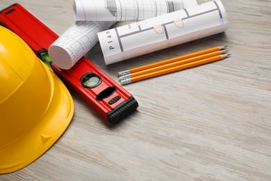 Photo of Building level and other construction tools on white wooden table, space for text