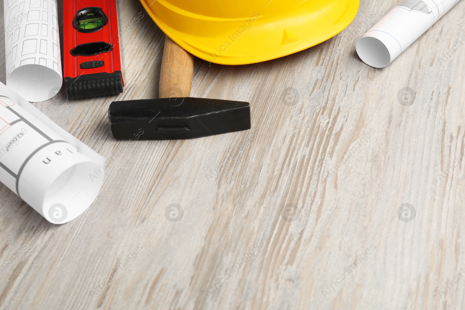 Photo of Building level and other construction tools on white wooden table, space for text