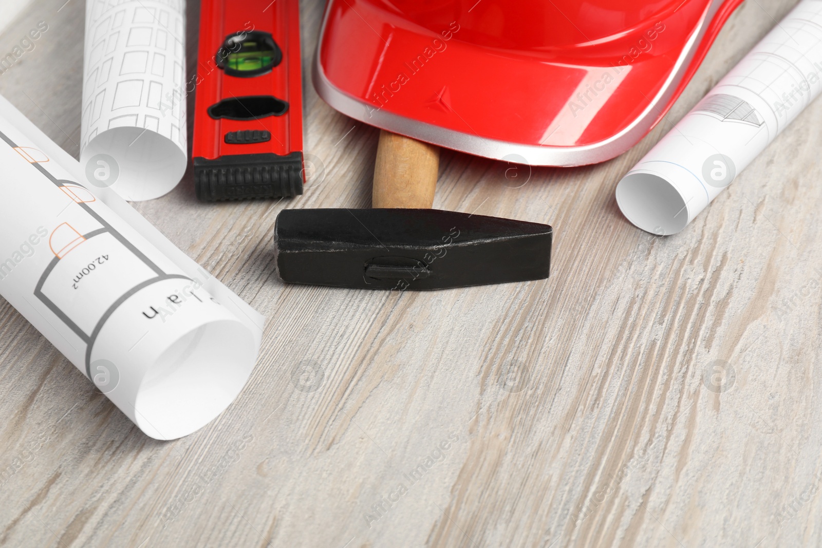 Photo of Building level and other construction tools on white wooden table, closeup. Space for text