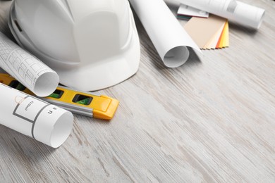 Building level and other construction tools on white wooden table, closeup. Space for text