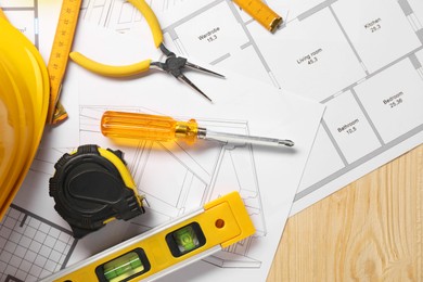 Photo of Flat lay composition with building level and other different construction tools on wooden background