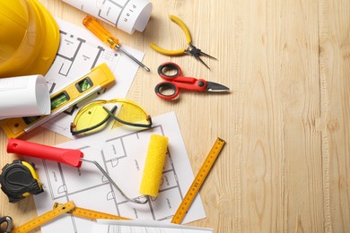 Photo of Flat lay composition with building level and other different construction tools on wooden background, space for text