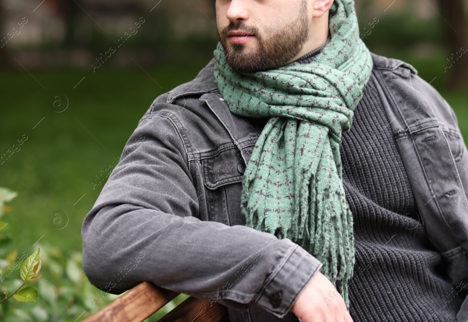 Photo of Man in warm scarf on city street, closeup