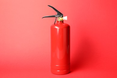 Photo of One fire extinguisher on red background. Safety equipment