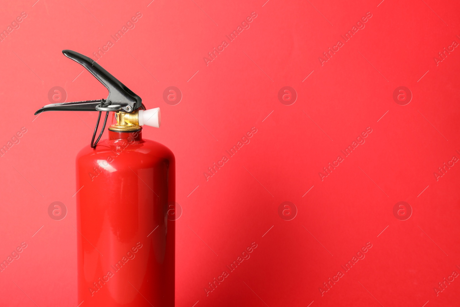 Photo of One fire extinguisher on red background, space for text