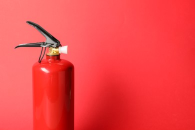 Photo of One fire extinguisher on red background, space for text