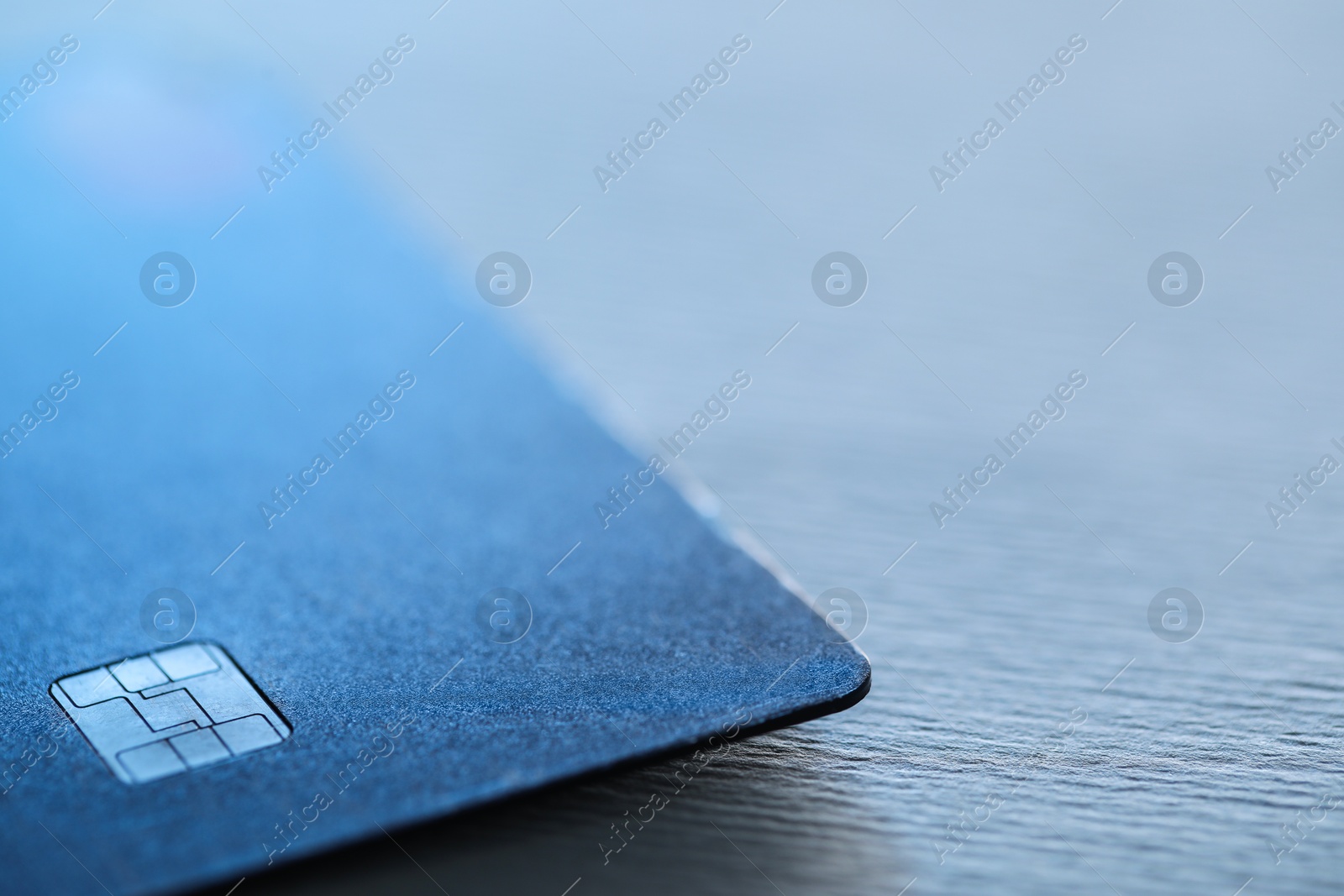 Photo of One credit card on gray background, macro view. Space for text