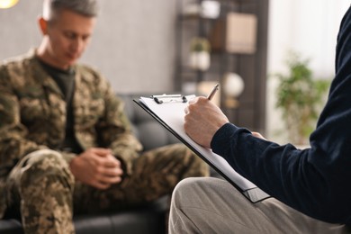 Professional psychotherapist working with military man in office, closeup