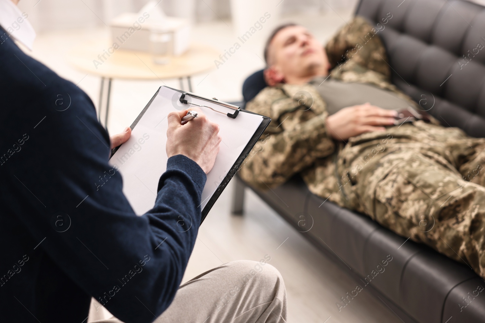 Photo of Professional psychotherapist working with military man in office