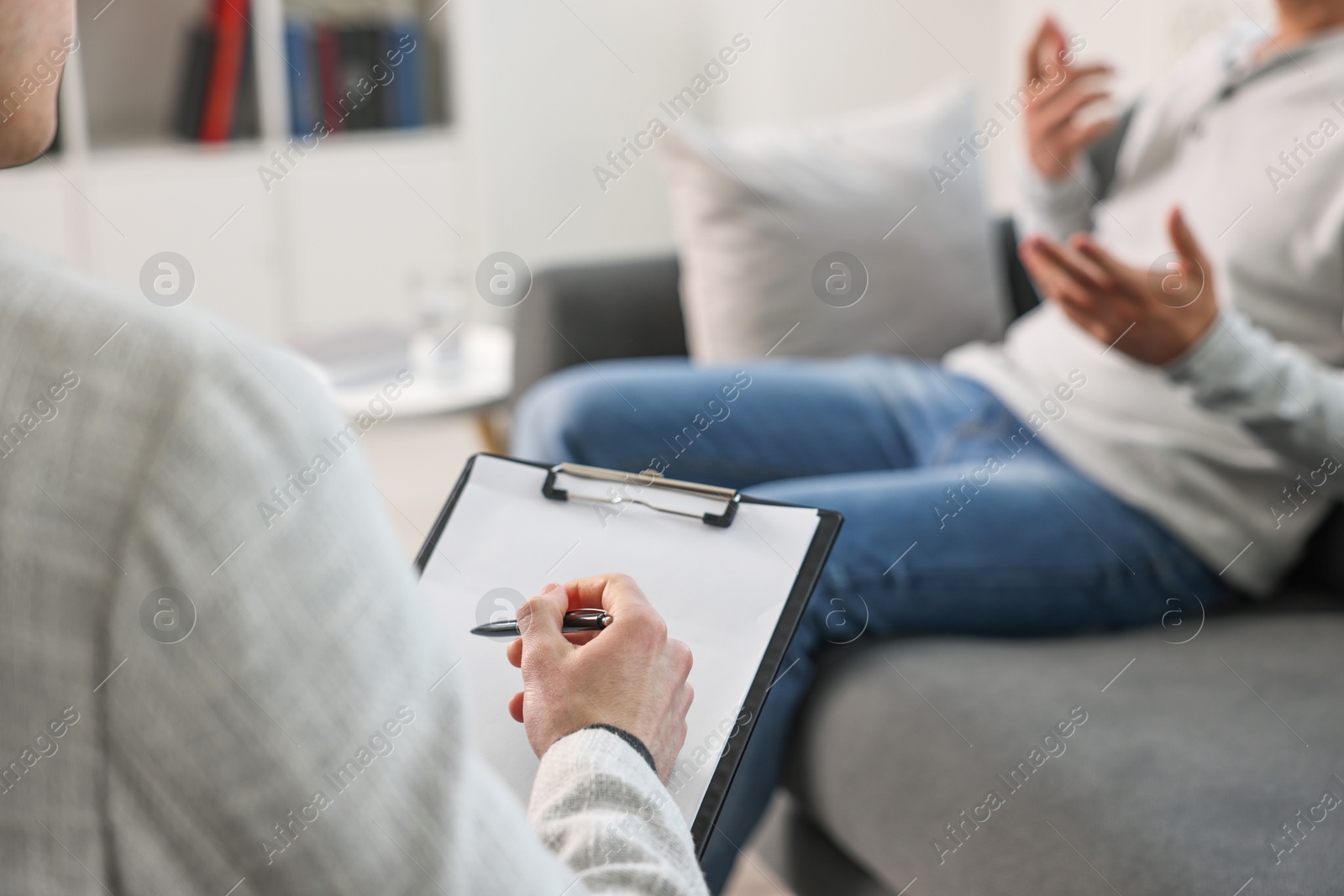 Photo of Professional psychotherapist working with patient in office, closeup