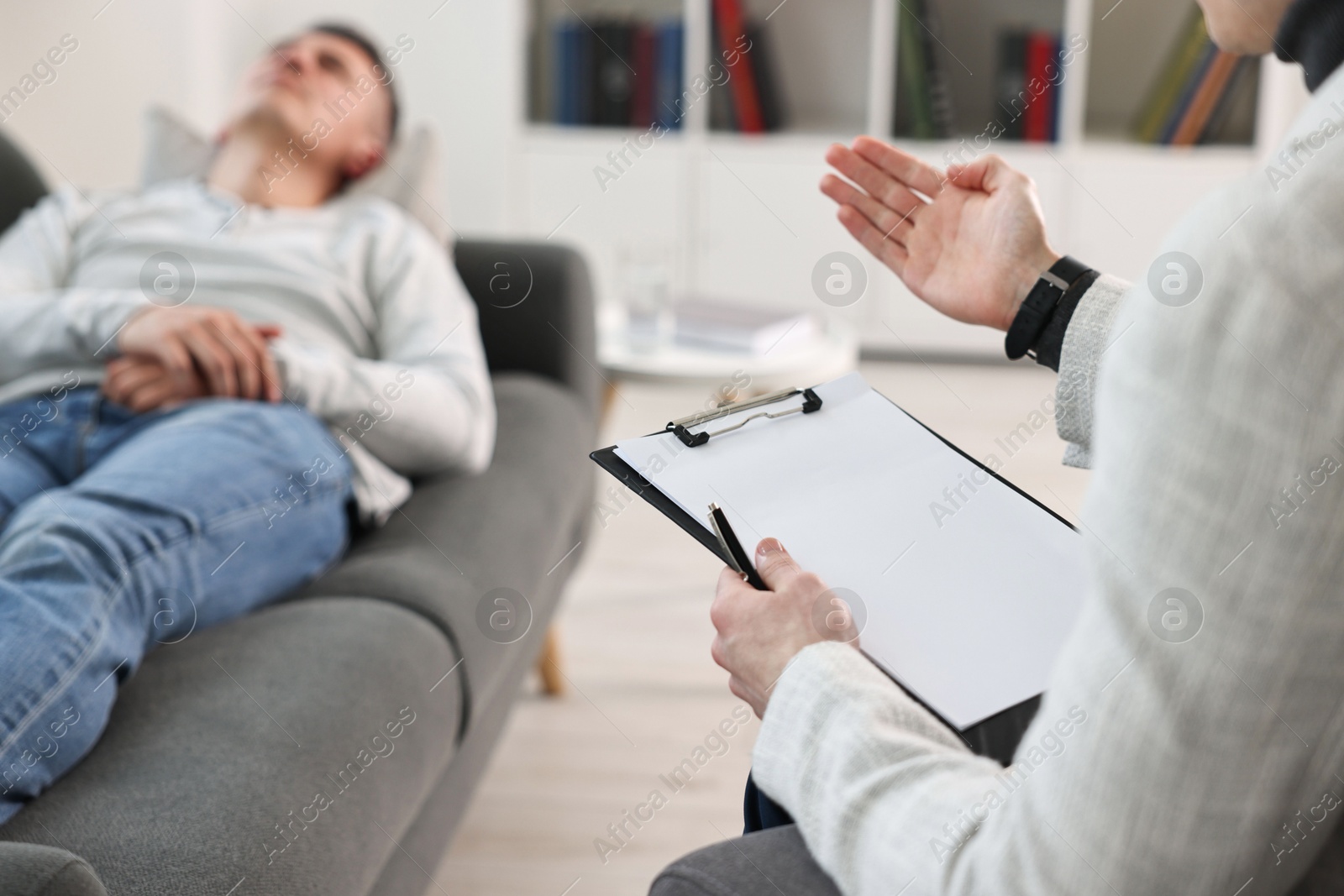 Photo of Professional psychotherapist working with patient in office, closeup