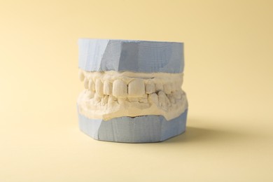 Photo of Dental model with gums on yellow background. Cast of teeth