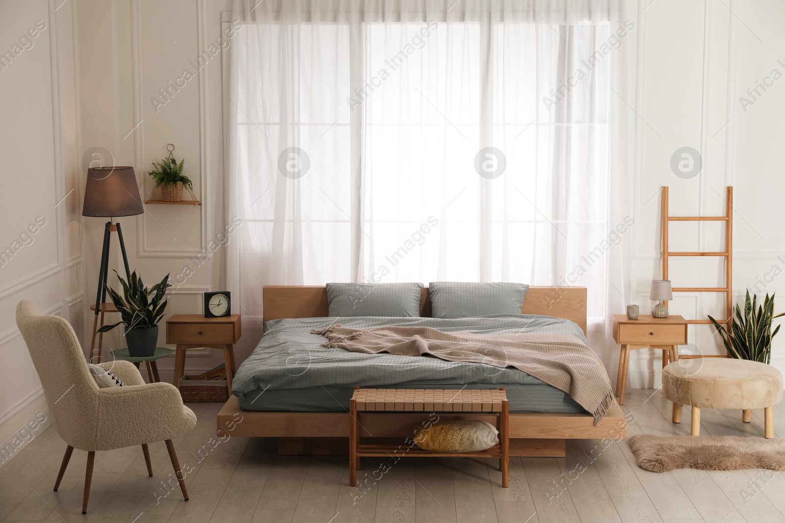 Photo of Stylish bedroom with double bed and beautiful green houseplants. Modern interior