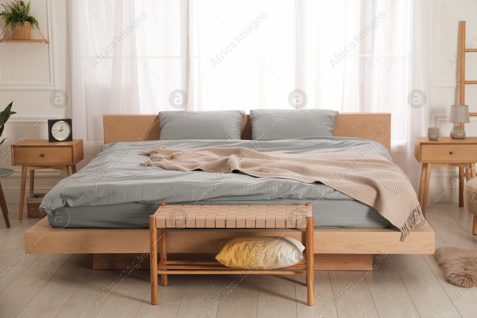 Photo of Stylish bedroom with double bed and beautiful green houseplants. Modern interior