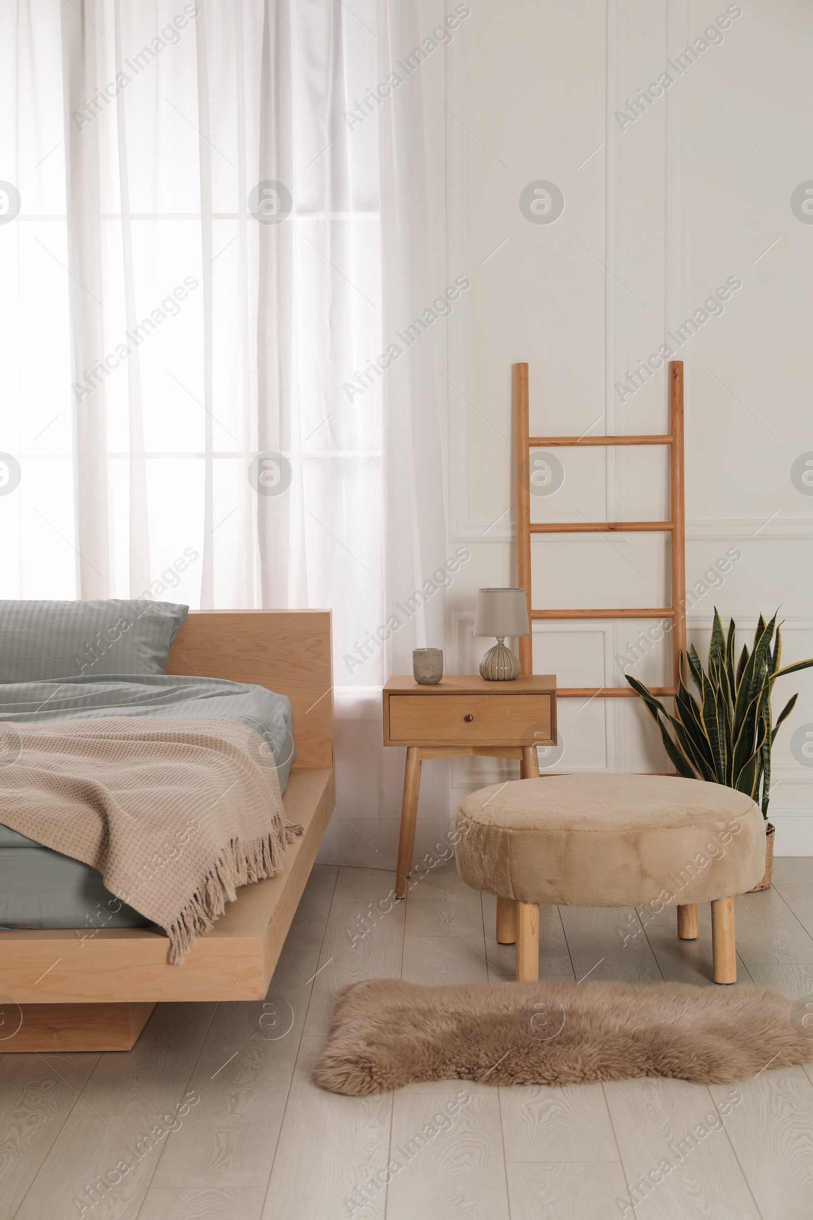 Photo of Stylish bedroom with double bed and beautiful green houseplants. Modern interior