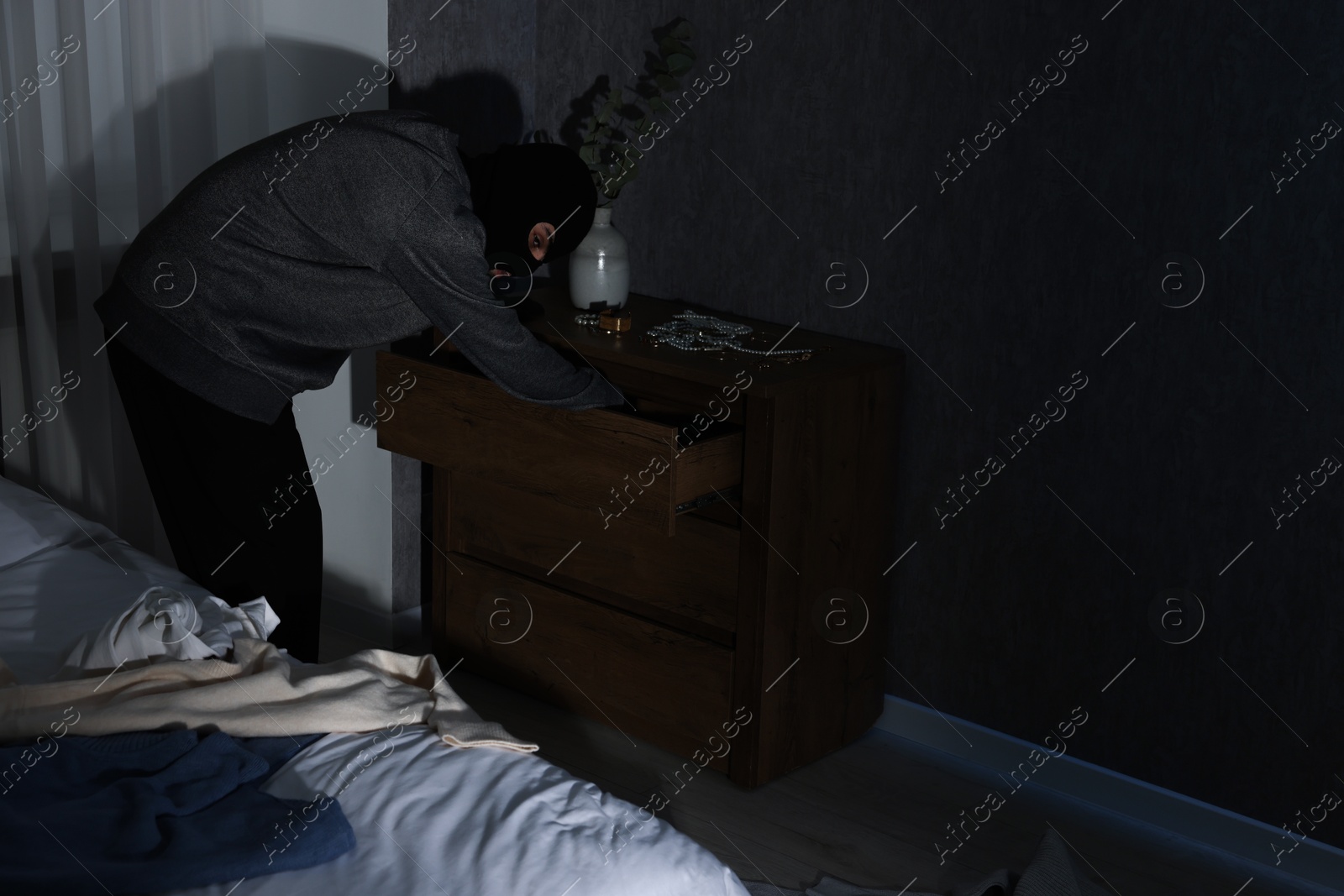 Photo of Thief stealing jewels in foreign house. Burglary