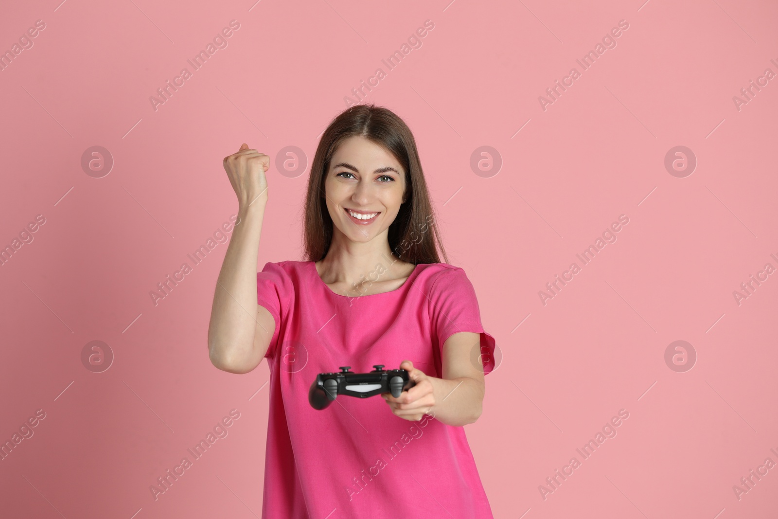 Photo of Happy woman with controller on pink background