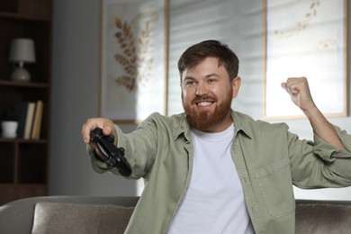 Photo of Happy man with game controller at home