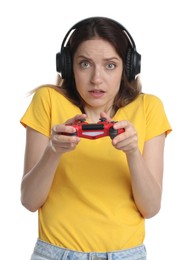 Emotional woman in headphones playing video game with controller on white background