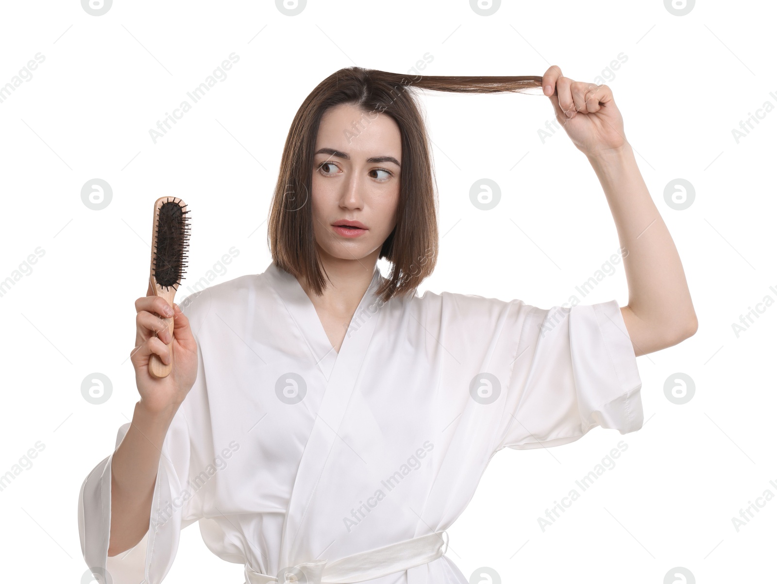 Photo of Stressed woman holding brush with lost hair on white background. Alopecia problem