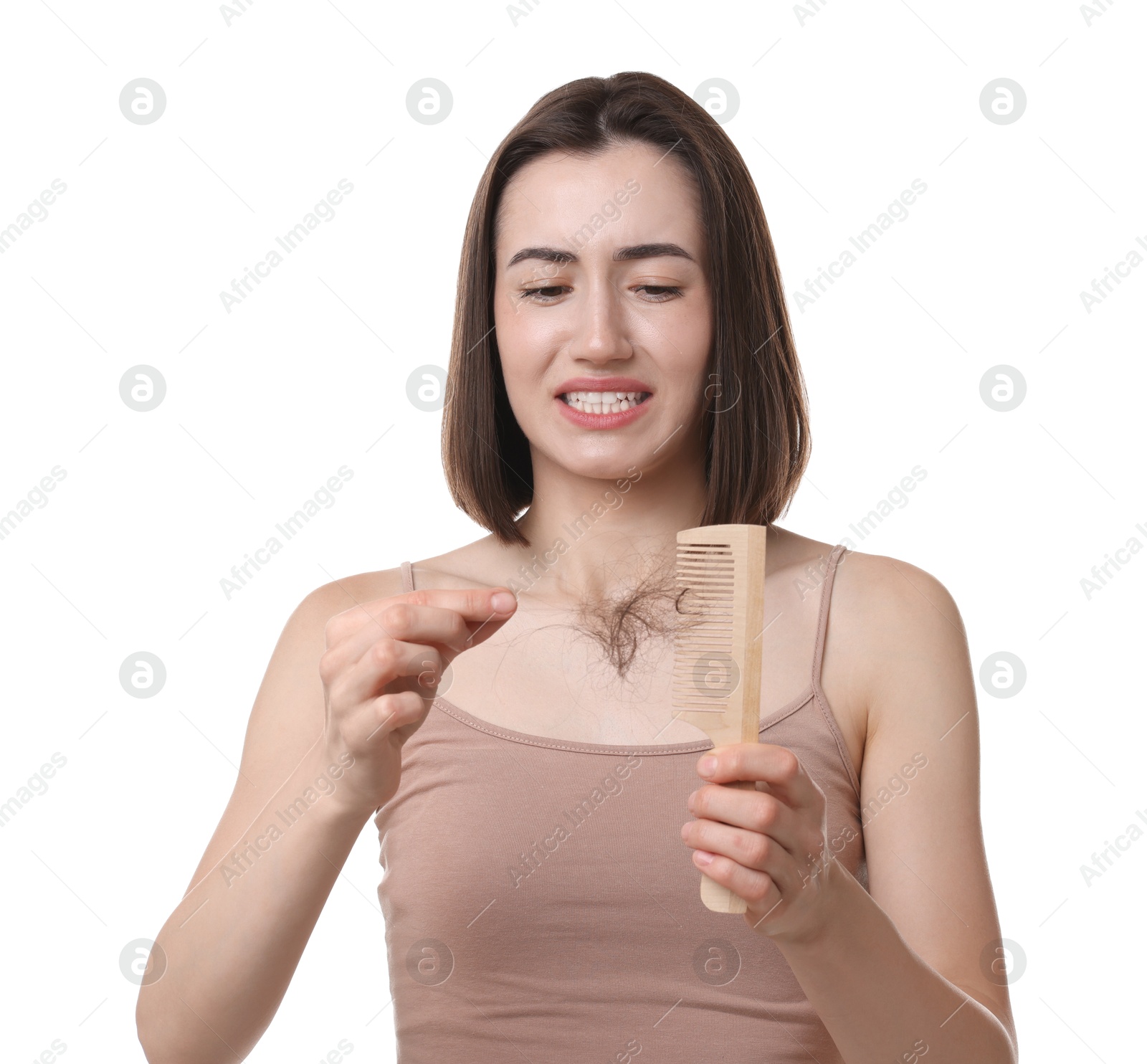 Photo of Emotional woman taking her lost hair from comb on white background. Alopecia problem