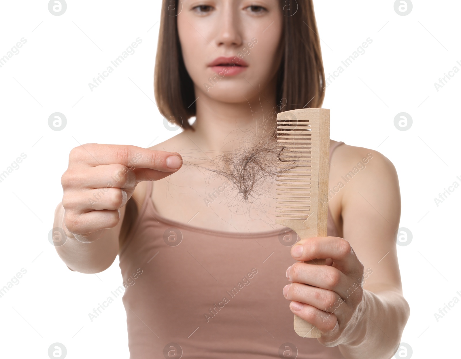 Photo of Woman taking her lost hair from comb on white background, selective focus. Alopecia problem