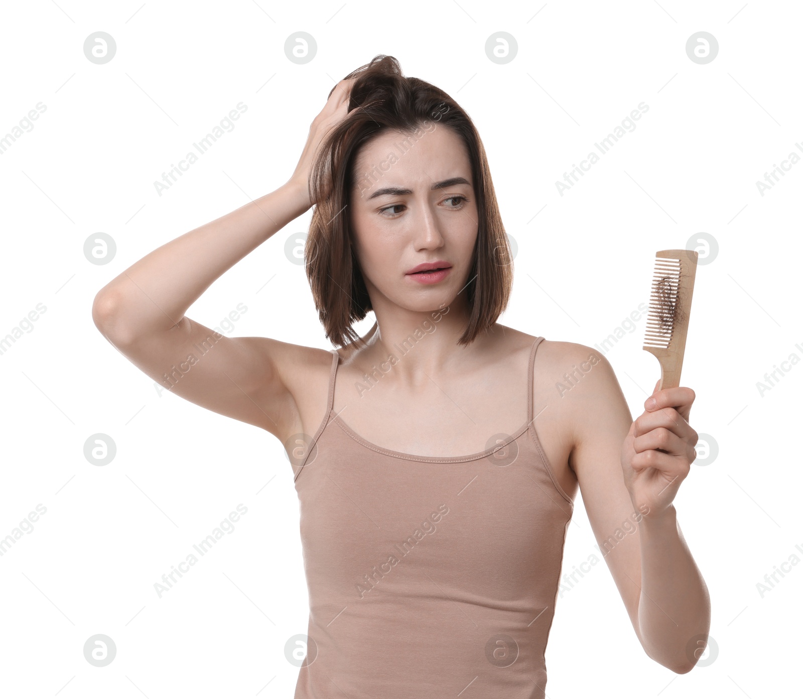 Photo of Stressed woman holding comb with lost hair on white background. Alopecia problem