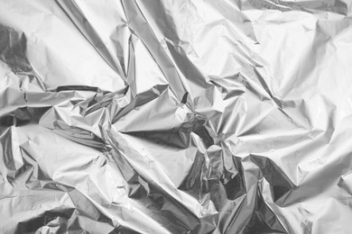 Crumpled silver foil as background, top view