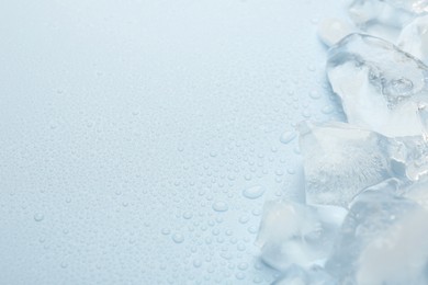 Photo of Pieces of crushed ice on light blue background, space for text