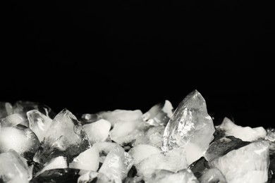 Photo of Pile of crushed ice on black background, space for text