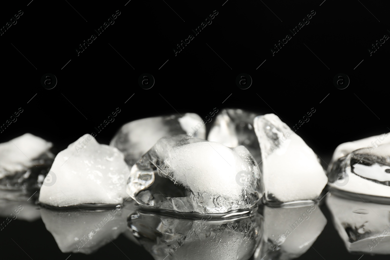 Photo of Pile of crushed ice on black mirror surface