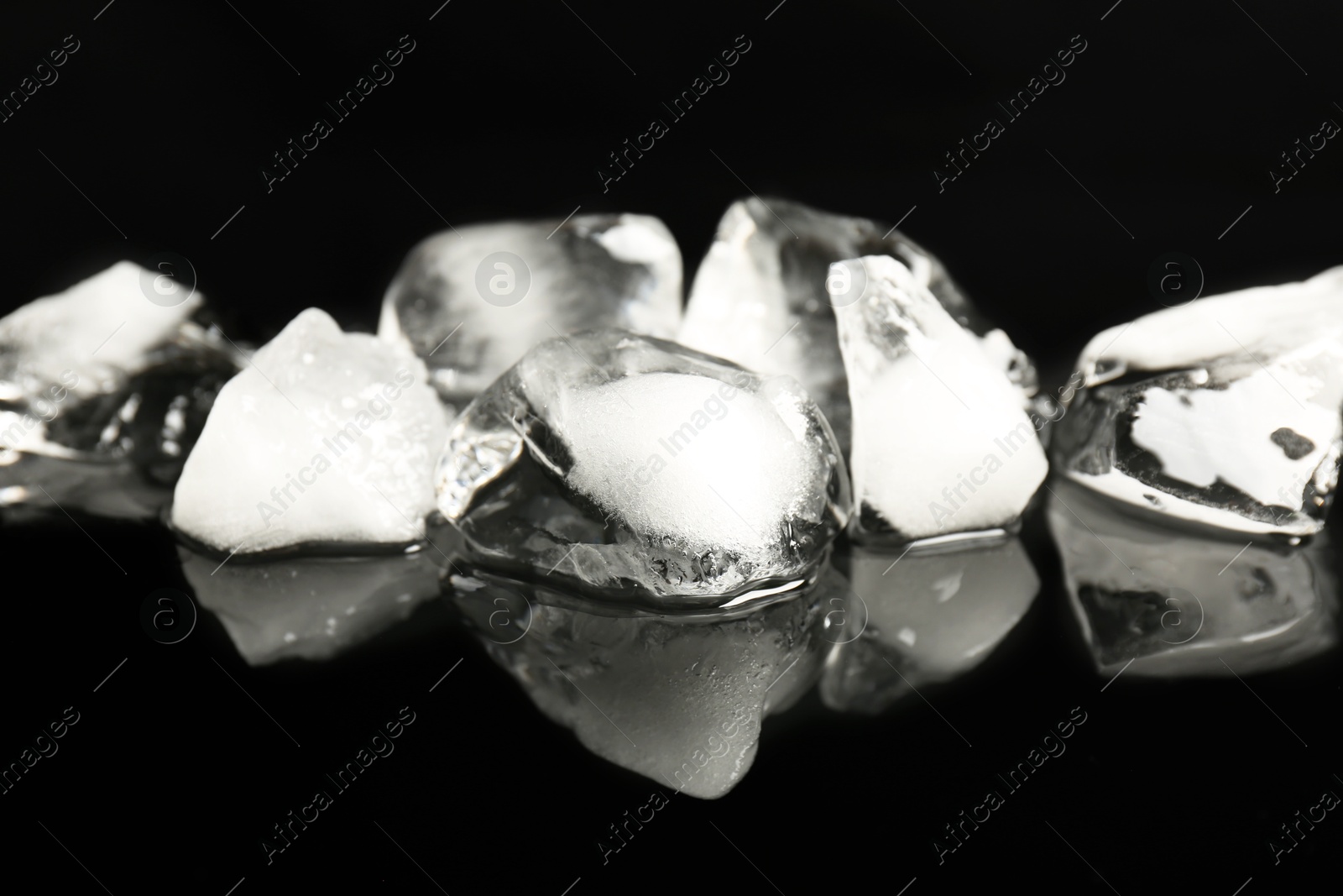 Photo of Pile of crushed ice on black mirror surface