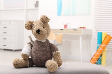 Photo of Toy cute bear with bandage and thermometer indoors, space for text