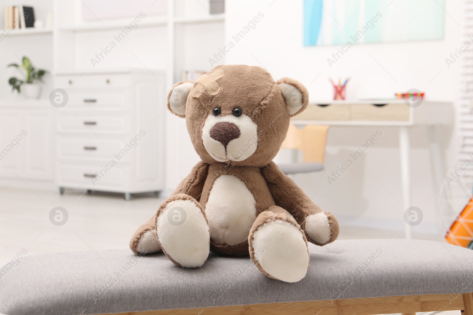 Photo of Toy cute bear with sticking plaster indoors