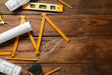 Photo of Flat lay composition with building level and other construction tools on wooden table, space for text