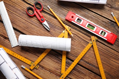 Flat lay composition with building level and other construction tools on wooden table