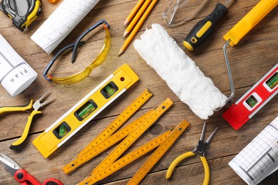 Flat lay composition with building level and other construction tools on wooden table