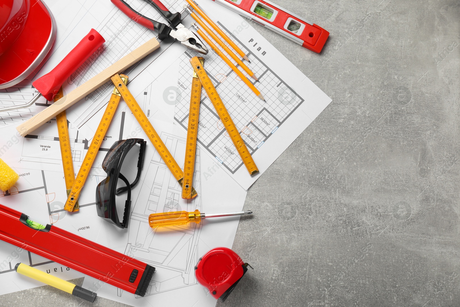 Photo of Flat lay composition with building level and other construction tools on grey table, space for text