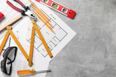 Photo of Flat lay composition with building level and other construction tools on grey table, space for text