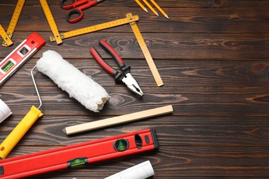 Photo of Flat lay composition with building level and other construction tools on wooden table, space for text