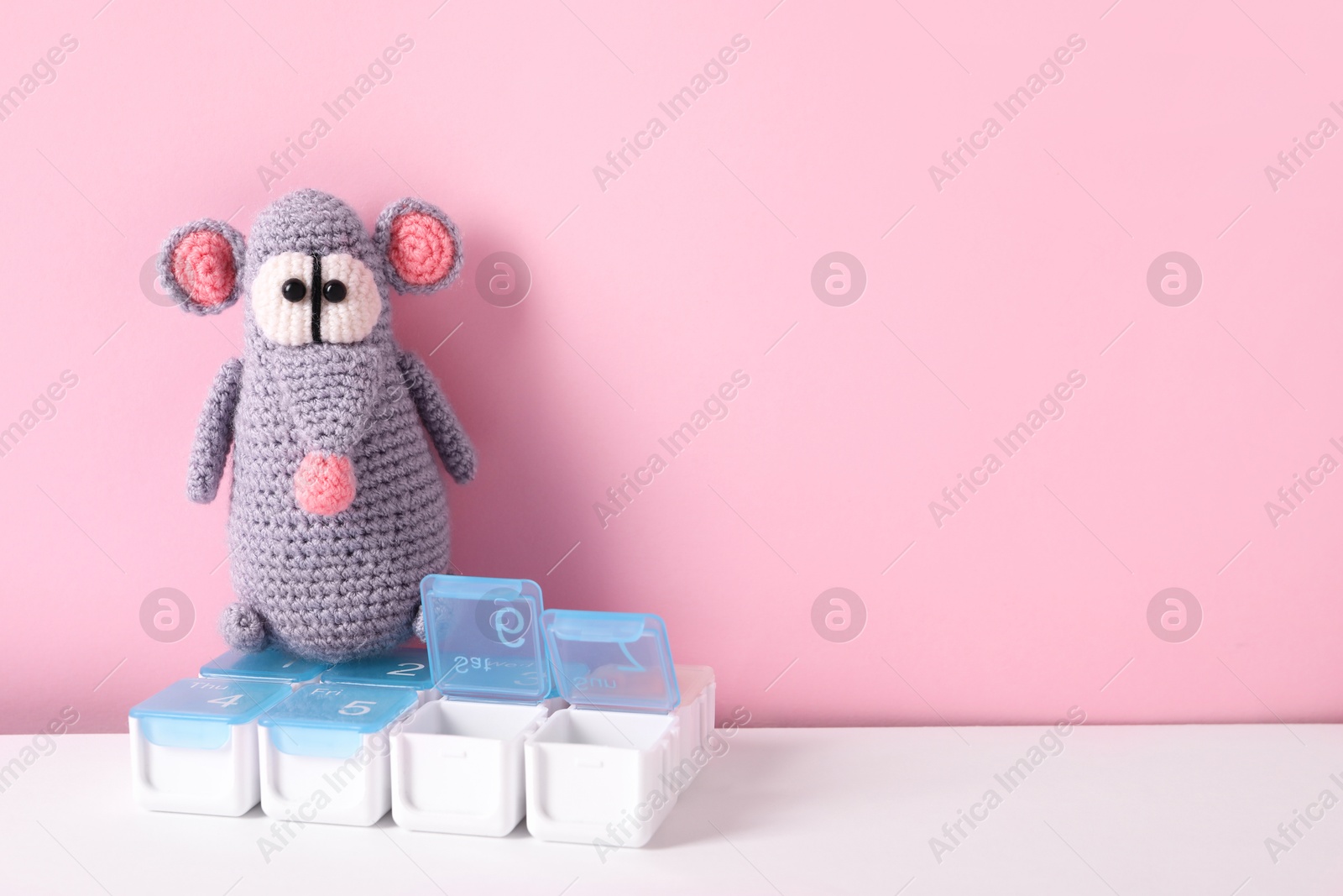 Photo of Toy rat and containers with pills on color background, space for text