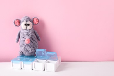 Toy rat and containers with pills on color background, space for text
