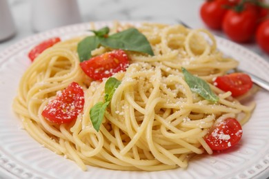 Tasty pasta with tomato, cheese and basil on table, closeup