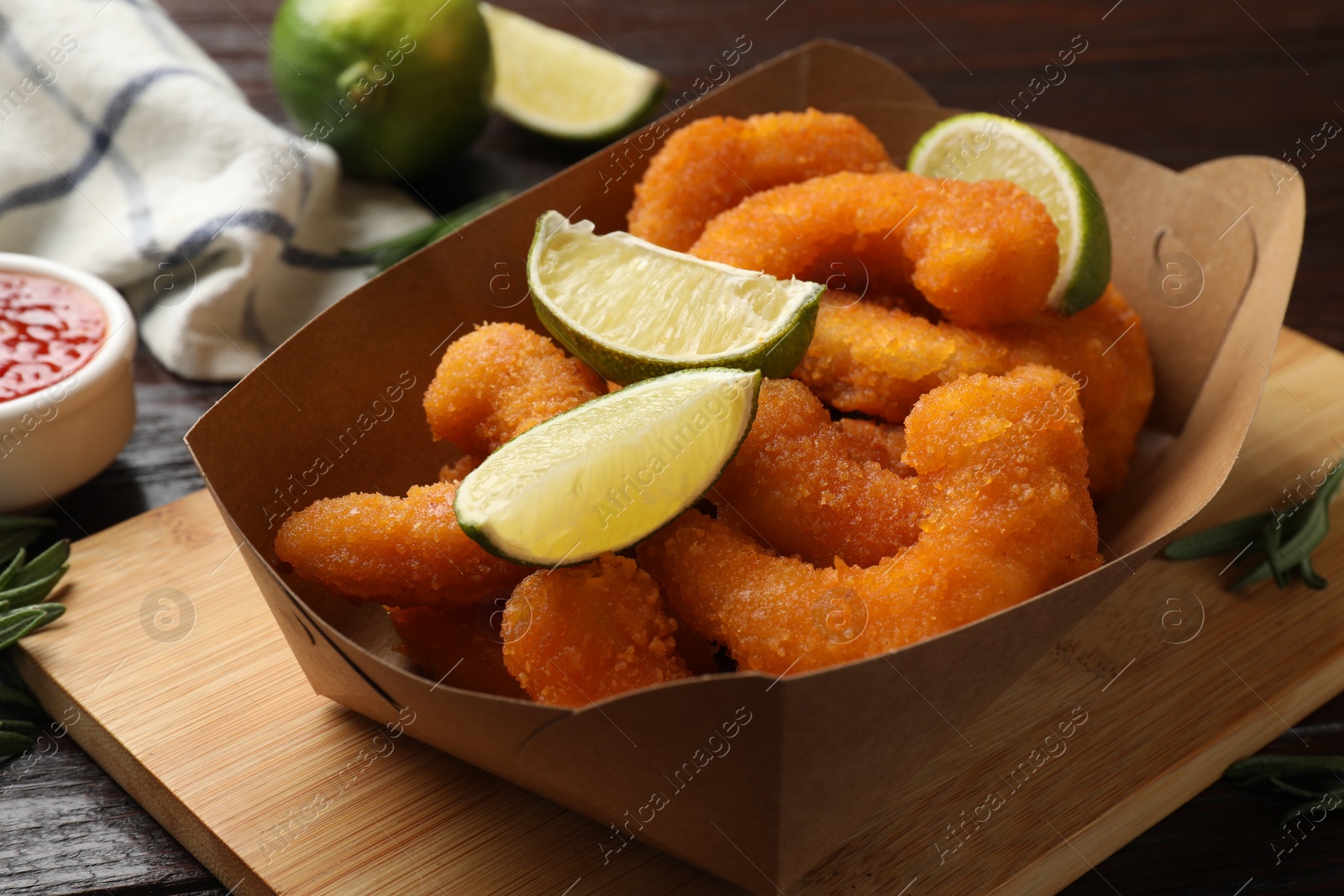 Photo of Delicious breaded fried shrimps and lime on table, closeup