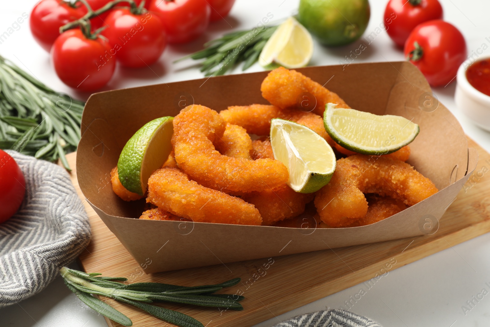 Photo of Delicious breaded fried shrimps served with lime on white table