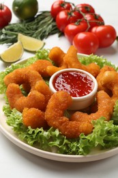 Photo of Delicious breaded fried shrimps served with sauce on white table